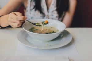 woman eating bowl of soup with a spoon